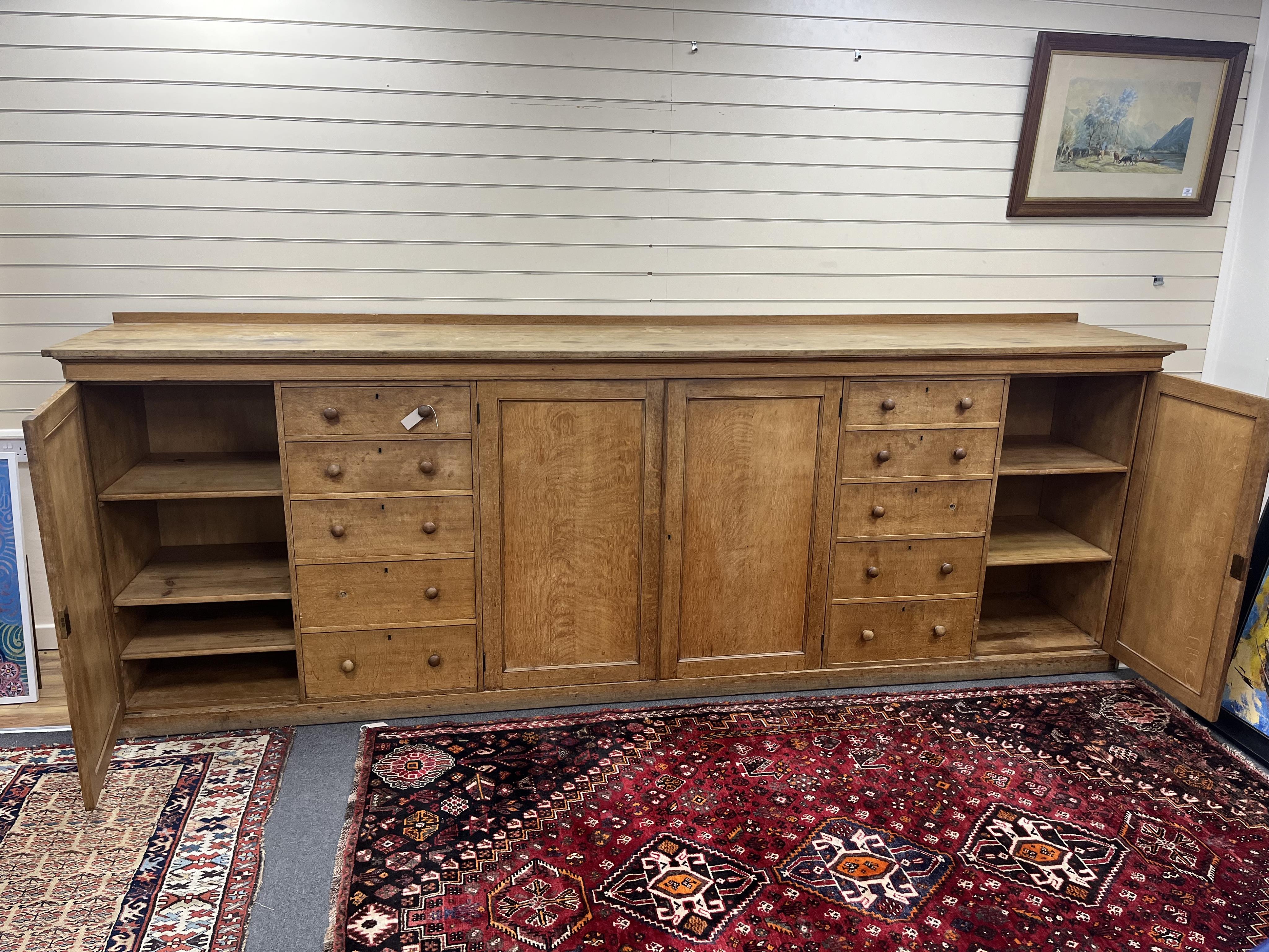 A late Victorian oak estate press cupboard, width 366cm, depth 64cm, height 130cm. Condition - fair